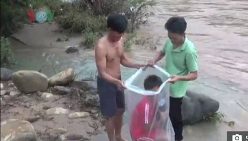 عبور عجیب 50 دانش آموزان با کیسه های پلاستیکی از یک رودخانه