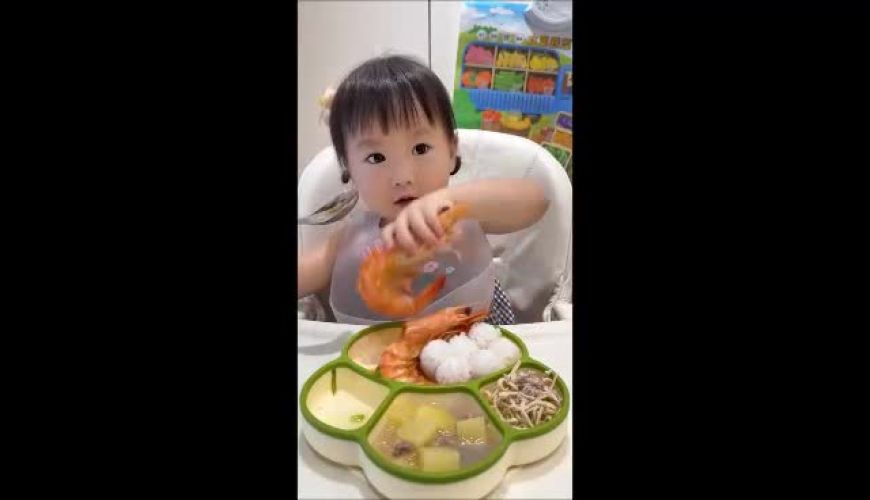 کودک خوش‌اشتها در کنار سینی غذای خانگی با ترکیب میگو، برنج و سبزیجات؛ ایده‌ای خلاقانه برای تشویق کودکان به خوردن غذاهای سالم